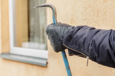 Soyguncu'nın el yakınındaki pencere levye ile