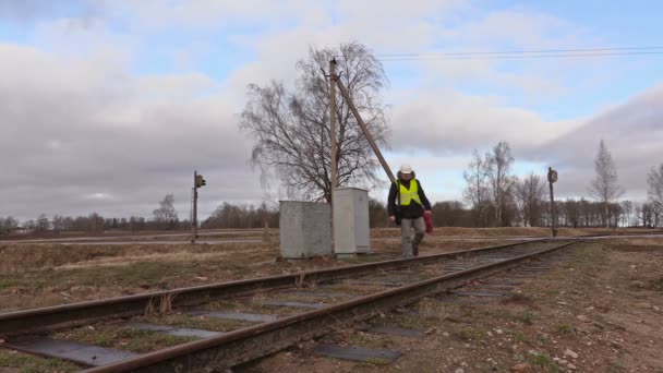 Électricien de chemin de fer avec câble marchant sur le chemin de fer — Video