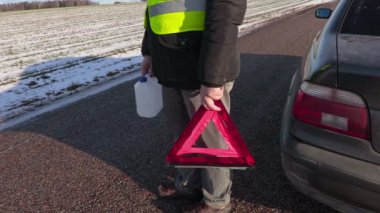 Adam boş olabilir ve uyarı üçgeni yakınındaki yolda araba 