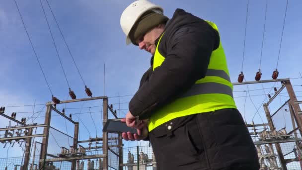 Engenheiro eletricista usando tablet perto da subestação e indo embora — Vídeo de Stock