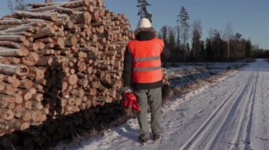 Günlükleri oduncu kar yakınındaki telefonda konuşurken chainsaw ile kaplı