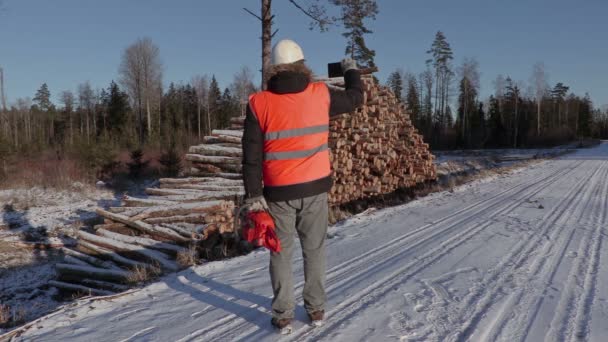 Skogshuggare med motorsåg ta bilder på smart phone — Stockvideo