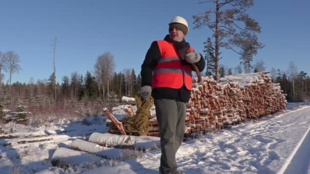 Lumberjack with rope and ax calling other workers and walking away — Stock Video