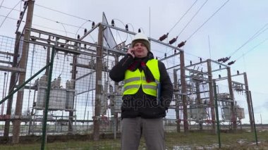 Trafo Merkezi yakınındaki akıllı telefon kışın konuşurken elektrikçi mühendisi