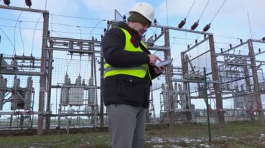 Elektrikçi mühendis tablet Trafo Merkezi yakınındaki kışın fotoğraf çekmek