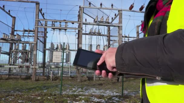 Инженер-электрик с помощью планшета вблизи подстанции — стоковое видео