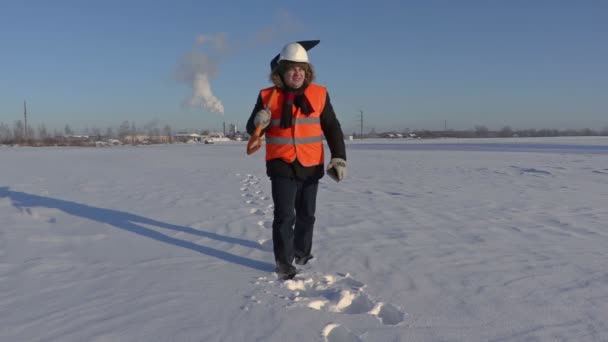 Trabajador con pala de nieve caminando y usando tableta en fábrica — Vídeo de stock