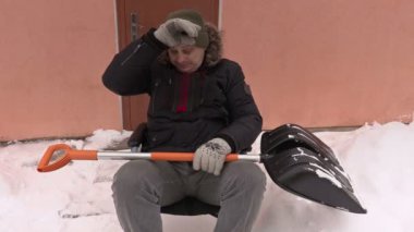 Tekerlekli sandalye ile kar üzerinde yorgun Engelli adam kürek 