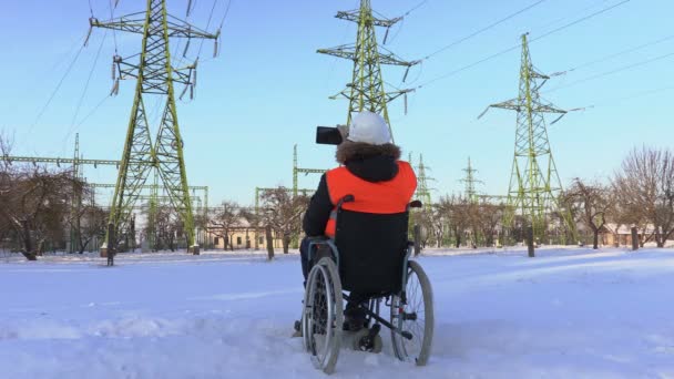 Pracownika niepełnosprawnego robić zdjęcia w pobliżu linii wysokiego napięcia — Wideo stockowe