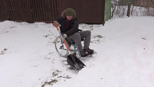 残疾的男子轮椅使用雪铲 — 图库视频影像