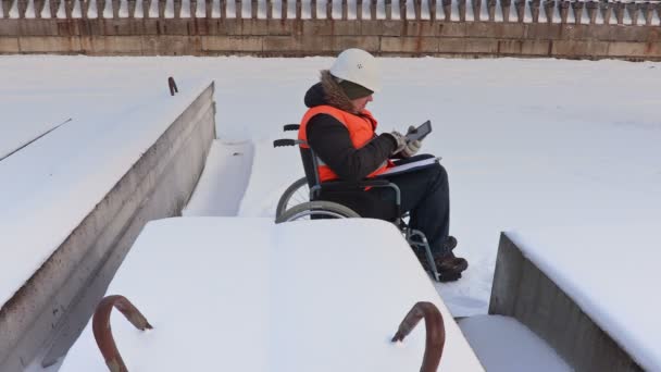 Trabajador discapacitado en silla de ruedas usando tableta y escritura — Vídeos de Stock