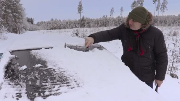 Man rengöra bilfönster från snön på vintern — Stockvideo