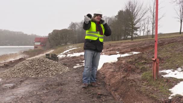 Werknemer met kunststofbuizen praten op cel — Stockvideo