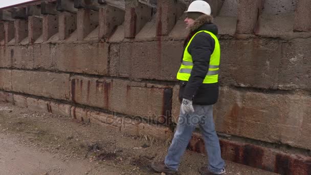 Stavební inženýr se fotit na profesionální fotoaparát na betonovou zeď — Stock video