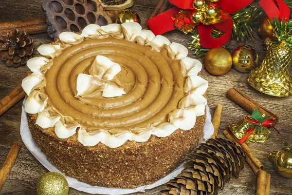 Chocolate cake on wooden table near Christmas decoration — Stock Photo, Image