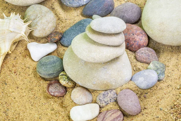 Pebbles stacked on sand — Stock Photo, Image