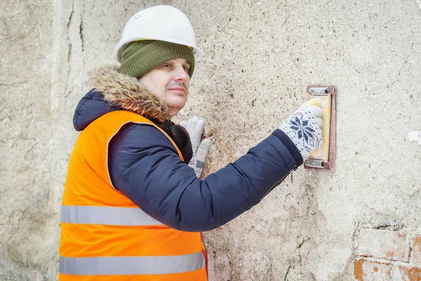 Builder använder slipverktyg och kontrollera väggen — Stockfoto