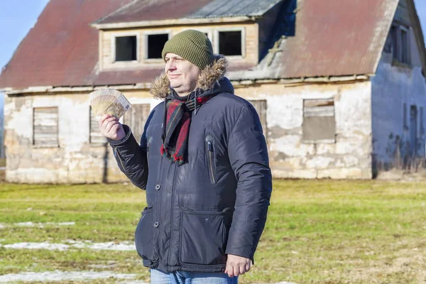 Homme avec billets en euros en main dans une maison abandonnée — Photo