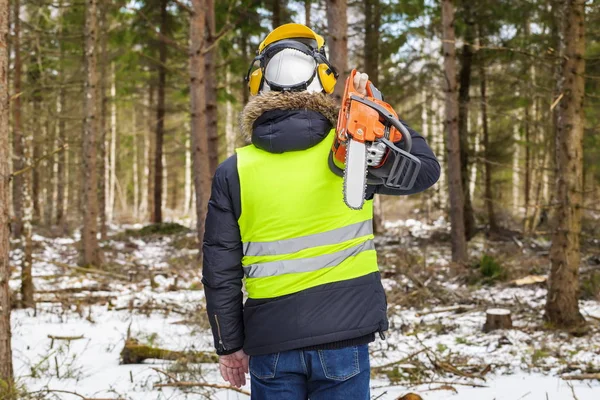 Madera con motosierra en el hombro en el bosque — Foto de Stock