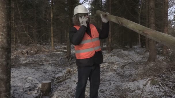 Dřevorubec s log na rameni mluví o telefonu — Stock video