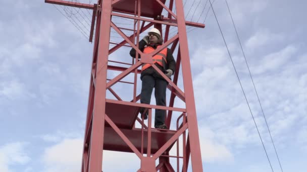 Ingenieur in de toren praten over slimme telefoon — Stockvideo