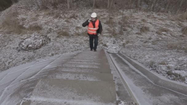 Ingenieur praten over telefoon en loop de trap — Stockvideo