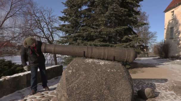 Турист возле старинного канона в средневековом замке — стоковое видео