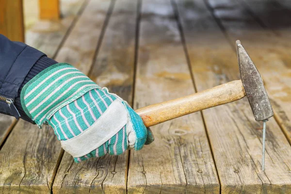 Trabajador clavo martillado en tablero de madera — Foto de Stock