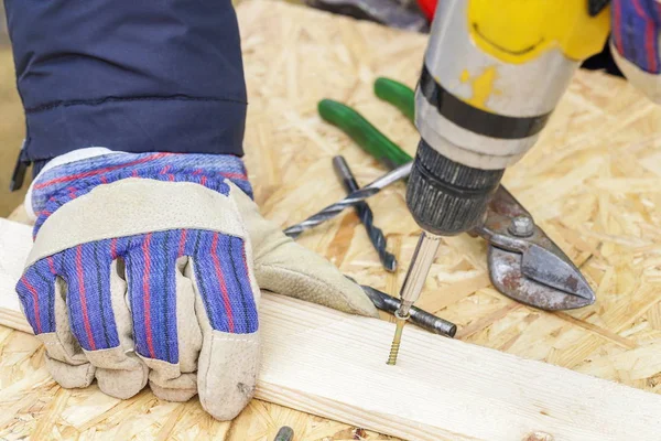Ręki pracownika na śruby i wiertła — Zdjęcie stockowe