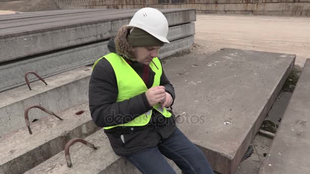 Pracownik budowlany próbuje Zapalić cygaretki — Wideo stockowe
