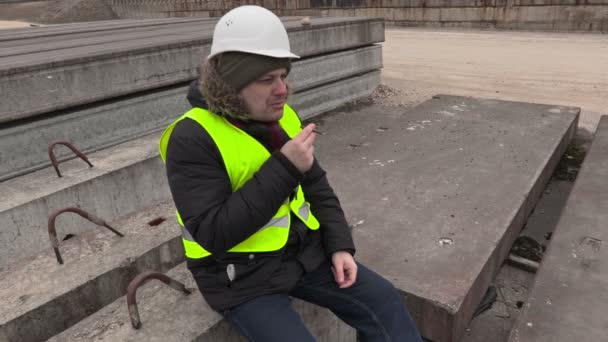Будівельник палить сигарили — стокове відео