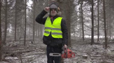 Kar fırtınası ormanında chainsaw ile oduncu