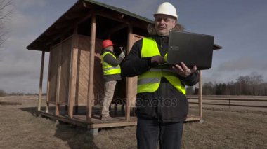 Dizüstü bilgisayar kullanarak ve yürüyüş inşaat mühendisi 