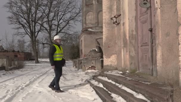 Engineer talking on phone near old building — Stock Video