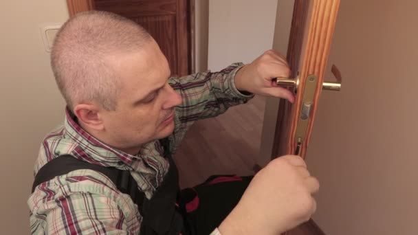 Arbetare med skruvmejsel nära dörrlås — Stockvideo