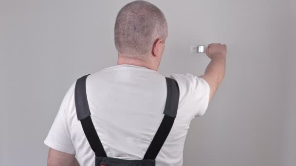 Werknemer met schilderij borstel in de buurt van de muur — Stockvideo