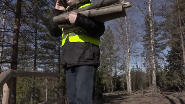 Werknemer met houten stukken praten aan de telefoon — Stockvideo