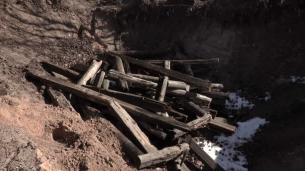 Рабочий бросает куски дерева в яму — стоковое видео