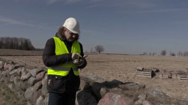 Bina müfettişi taş duvarının yakınında tablet kullanma