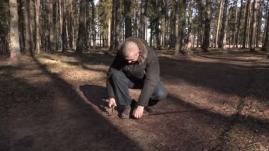 Adam sopa yolda hiking ile spor ayakkabıları bağlı