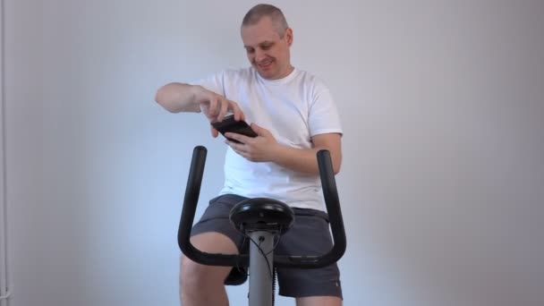 Man takes selfies on exercise bike — Stock Video