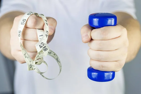 Man with small dumbbell and tape measure — Stock Photo, Image