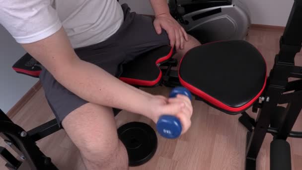 Уставший человек делает упражнения с маленьким гантели — стоковое видео