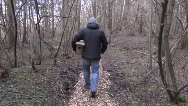 Homem com casa de pássaros e martelo caminhando no caminho — Vídeo de Stock