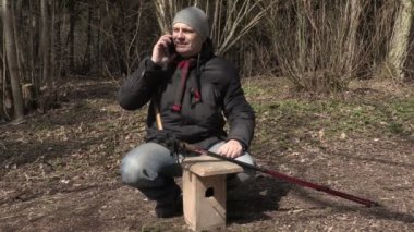 Kuş yuvası ve gösteri başparmak yakınındaki telefonda konuşan adam