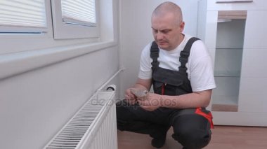 Radyatör yakınındaki para sayma adam