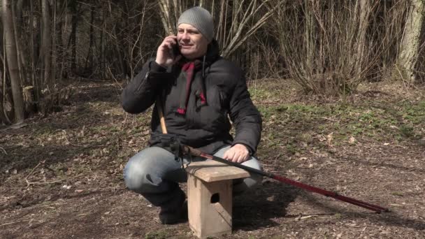 Muž mluví o telefonu poblíž ptačí budku a Ukázat palec — Stock video