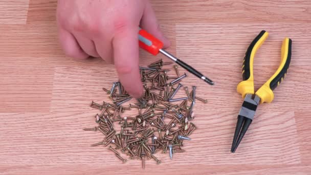 Hombre clasificando tornillos metálicos — Vídeos de Stock