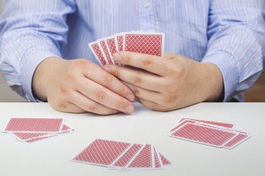 Erkekler beyaz masada poker kartları ile