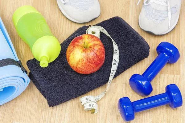 Pomme avec ruban à mesurer sur serviette avec appareil de fitness autour — Photo